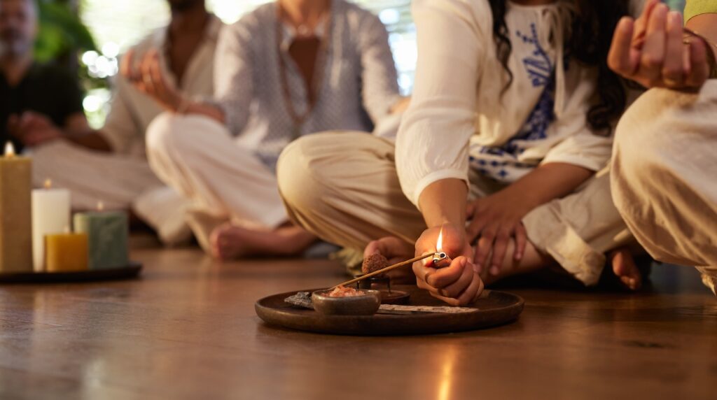 Close up hand of young woman lighting insence stick