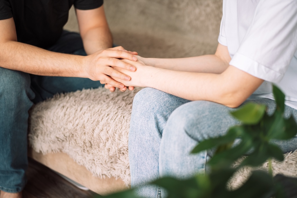 Therapist holding clients hand during therapy session