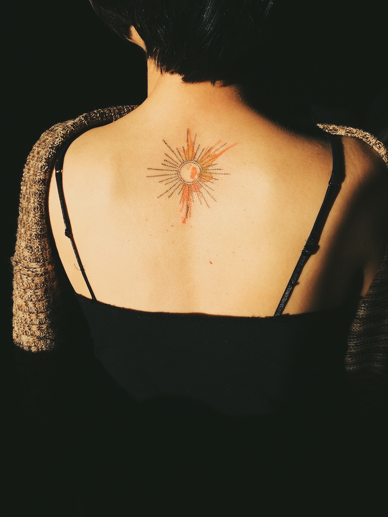Sun tattoo representing hope and healing in PTSD