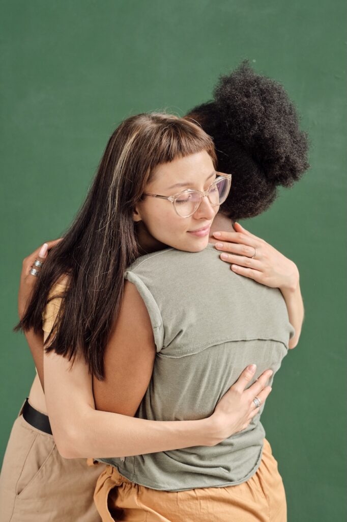 Two young women healing and hugging each other