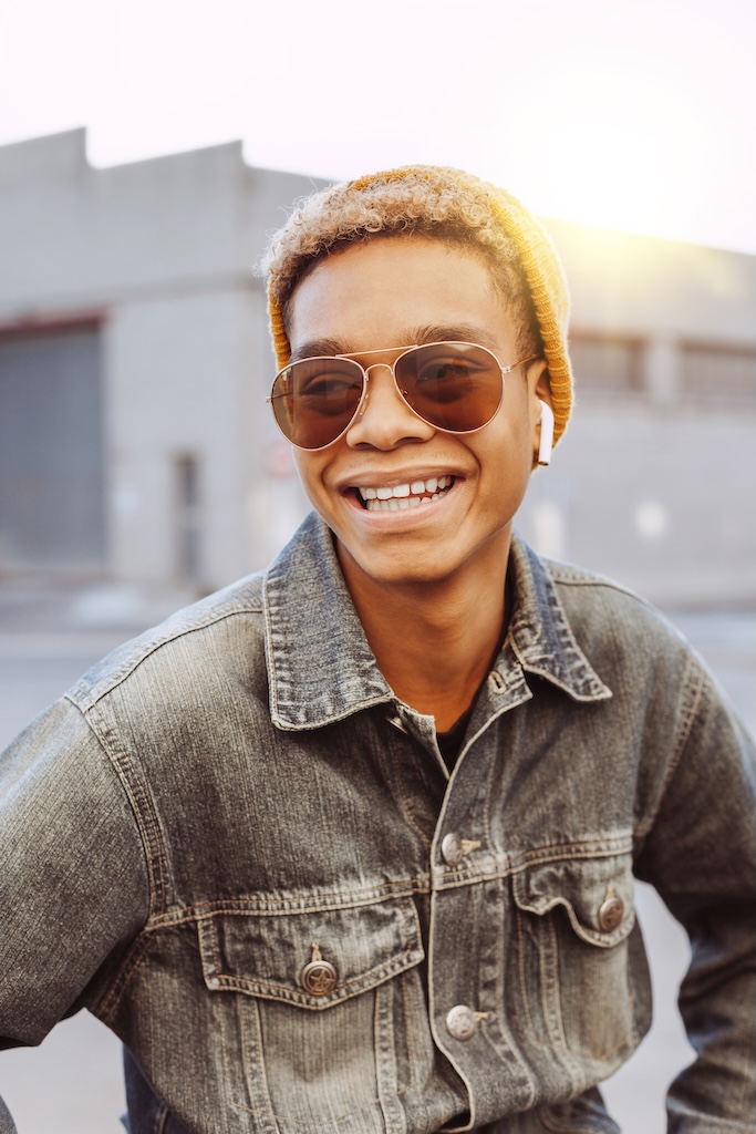 Glad young man feels great, wears in winter clothes and sunglasses