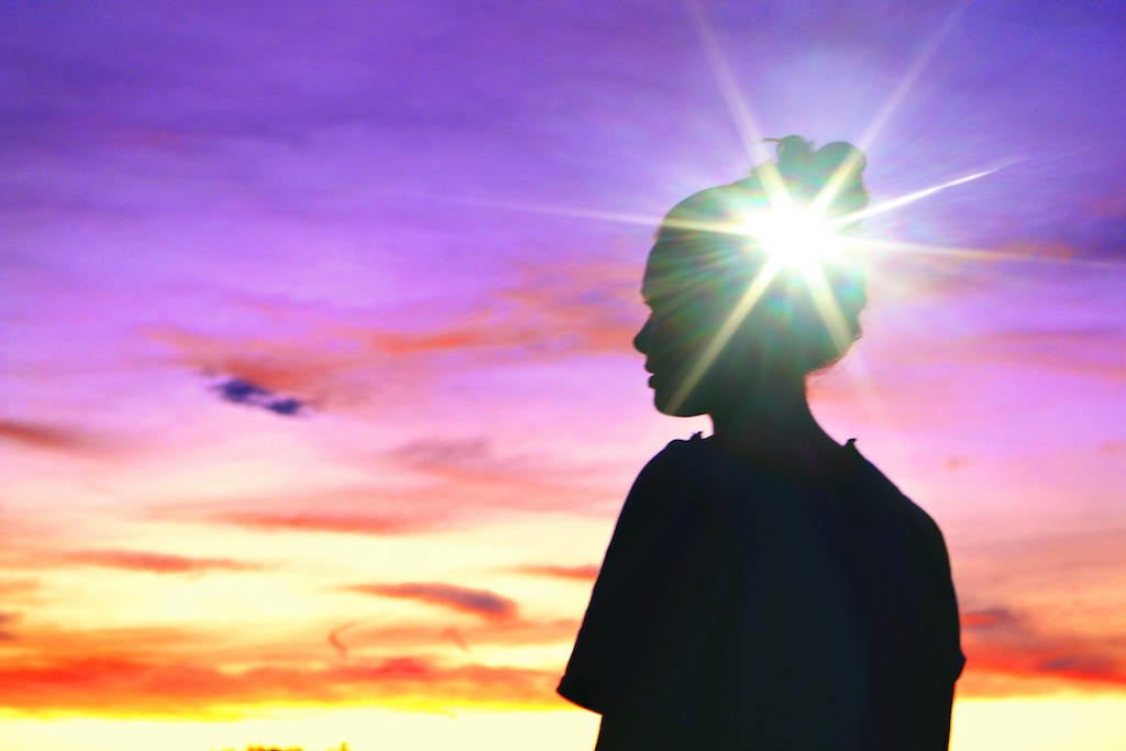 Person looking at the sky, dark isolated figure against colorful sky