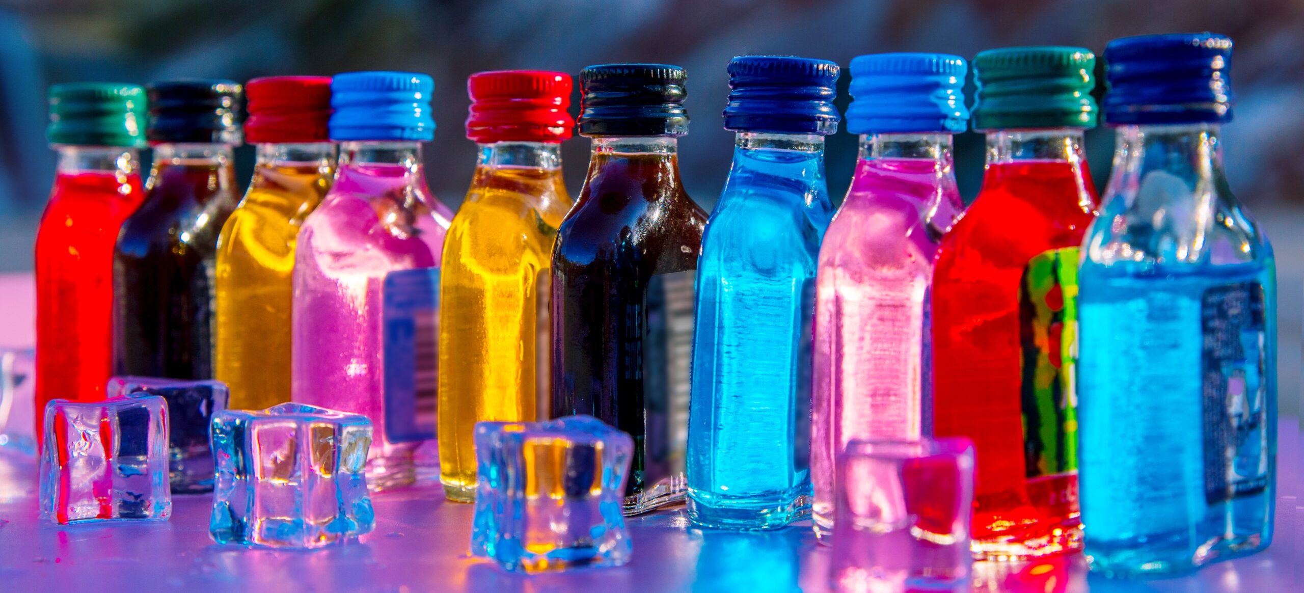 Table with neon lights full of small liquor bottles