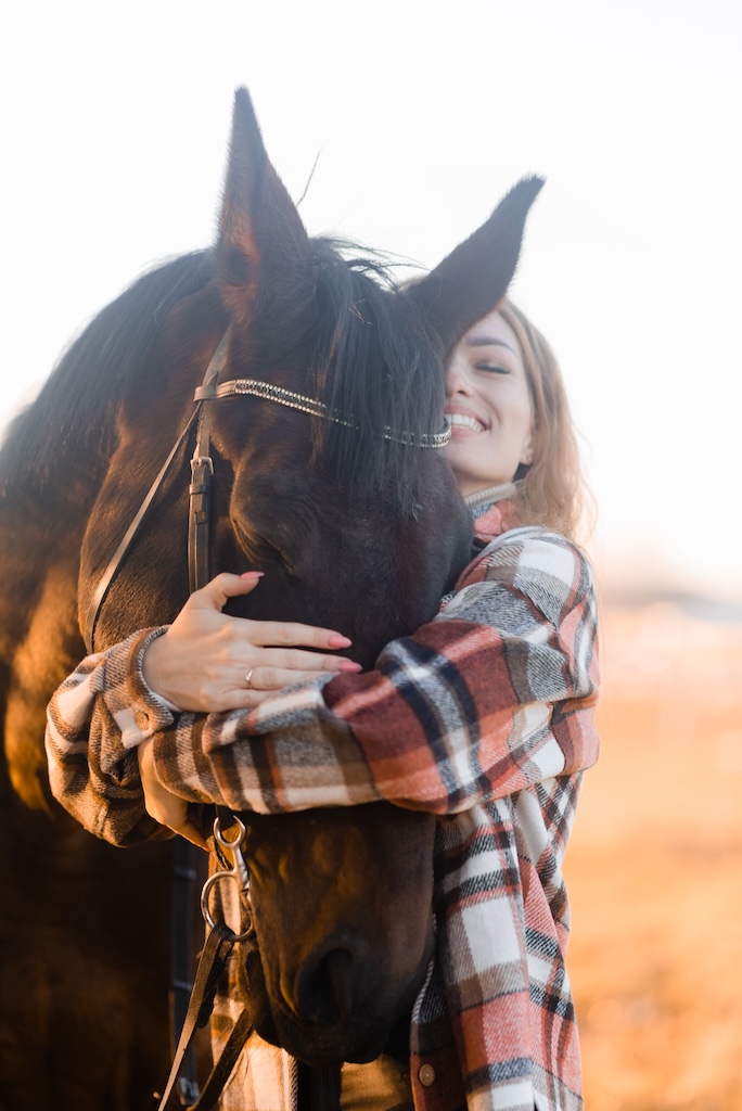 Young person hugging her horse