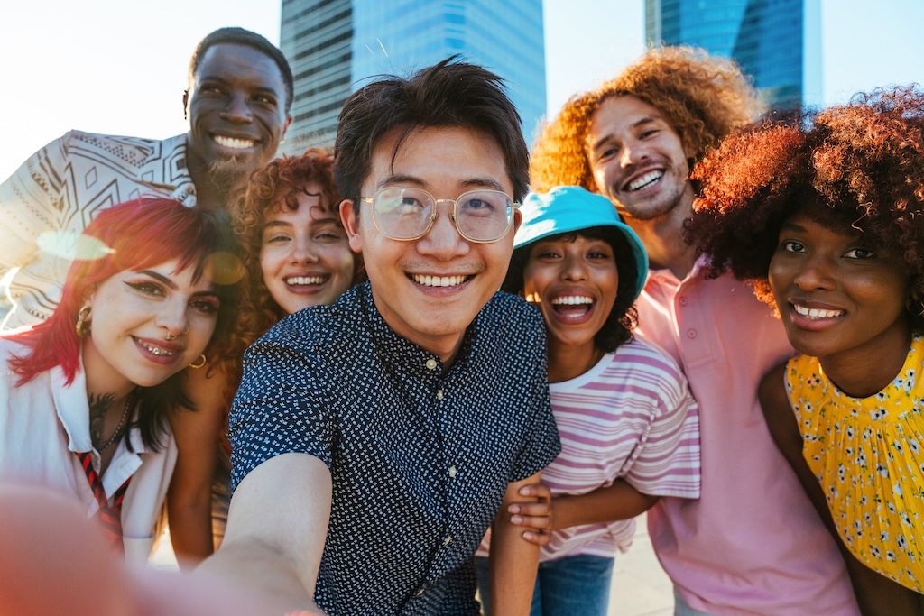 Multiethnic group of young friends meeting and having fun outdoors