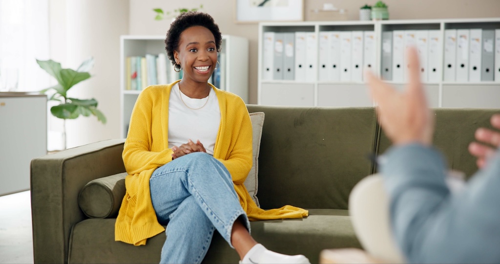 Psychology, therapist and woman on couch with smile, counseling and hope for anxiety management.
