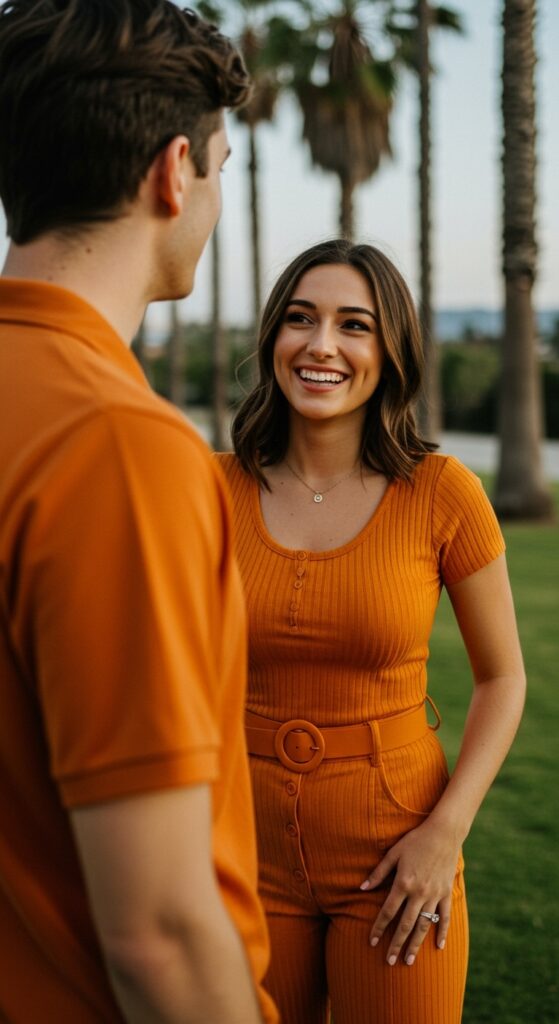 Young woman smiling at a male, both wearing orange