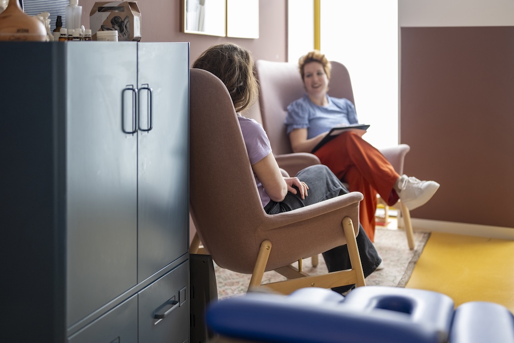 Two people having a conversation in a colorful room.