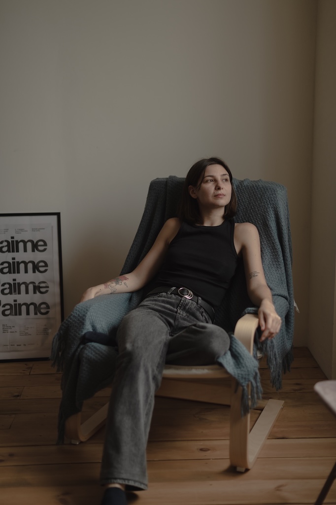 Young person lounging in chair looking out the window