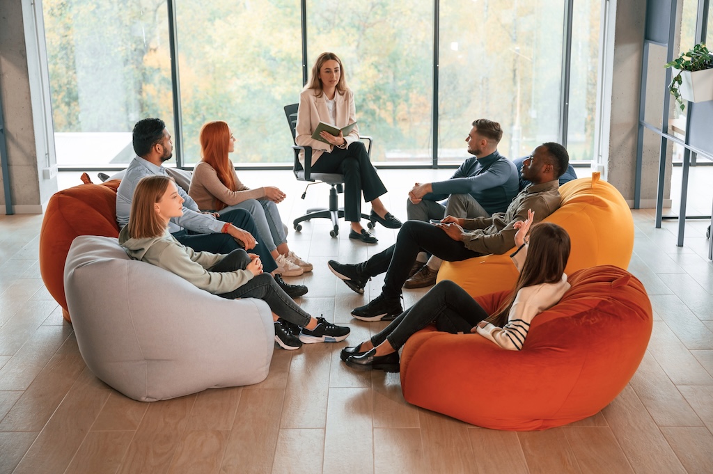 Sitting at the circle. Group of people are having therapy meeting together.