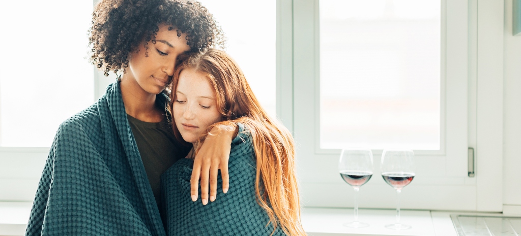 multiethnic lesbian couple covered in a blanket