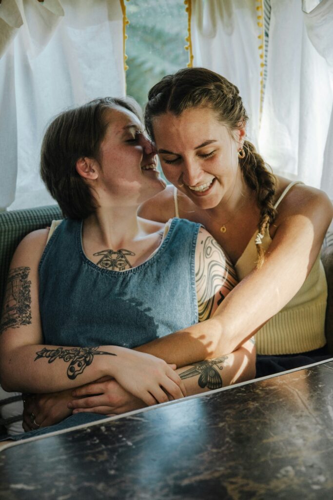 Two women embracing in a sunlit space, representing connection and trauma-informed support at an LGBTQ+ addiction treatment center in San Diego