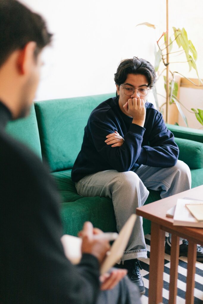 Client in one-on-one therapy session discussing trauma with clinician in a supportive, affirming setting for mental health treatment and trauma-focused care