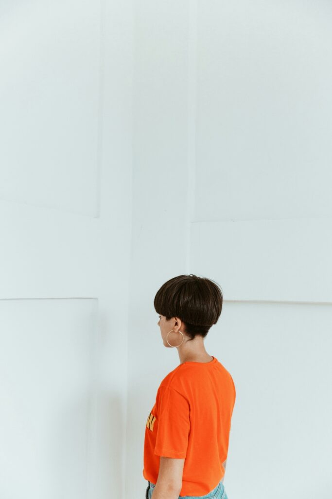 Person standing in a calm, minimalist space designed to reflect sensory-aware and neurodivergent-affirming mental health treatment.