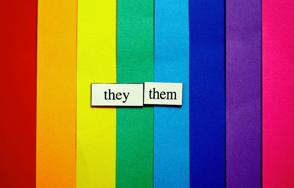 They/them pronoun tiles displayed on a rainbow background representing gender identity, self-expression, and LGBTQIA+ inclusion.