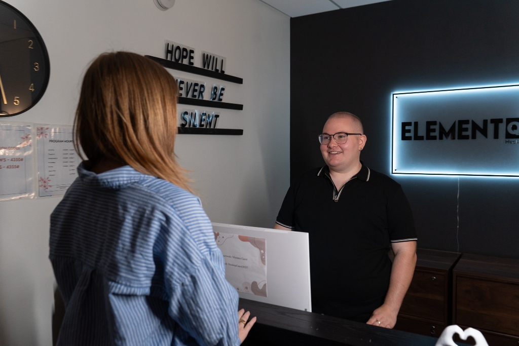 Reception staff member welcoming a client at Element Q Healing Center, reflecting an LGBTQIA+ affirming and supportive treatment environment.