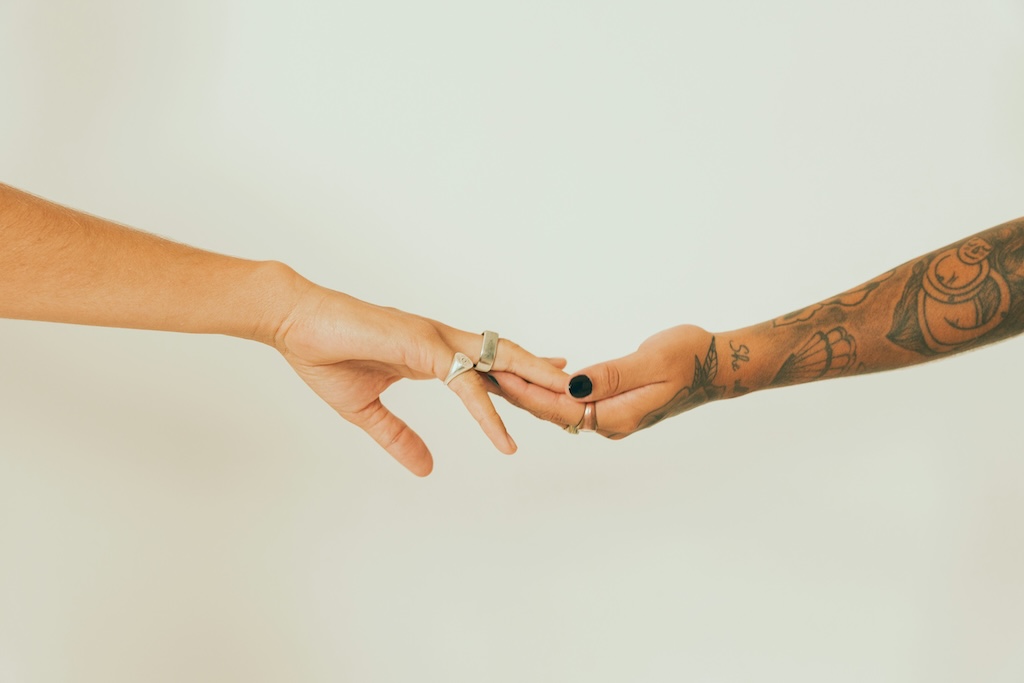 Two people reaching toward each other, illustrating connection and relationship anarchy.
